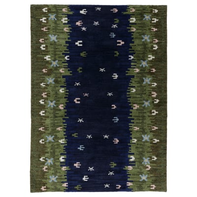 Handgeweven GRODDSVINGEL tapijt met groen, blauw en wit bloemendessin op een marineblauw midden. Wol en katoen materiaal, rechthoekige vorm.