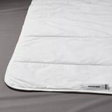 Wit GRUSSTARR dekbed op grijs beddengoed. Zachte, verkoelende stof met viscose vulling voor comfort.