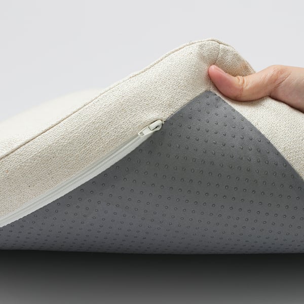 Een hand die een gedempte stoelbekleding optilt en de ritssluiting laat zien.