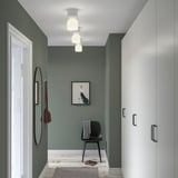 Moderne groene hal met HAMNFYR lampen, stoel, spiegel en kast.