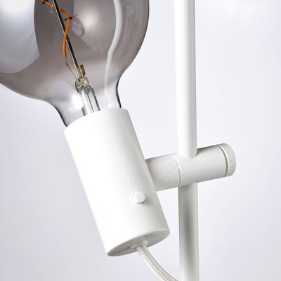 Een witte HÅRSLINGA vloerlamp met een strak design, instelbaar licht en een stabiele voet.