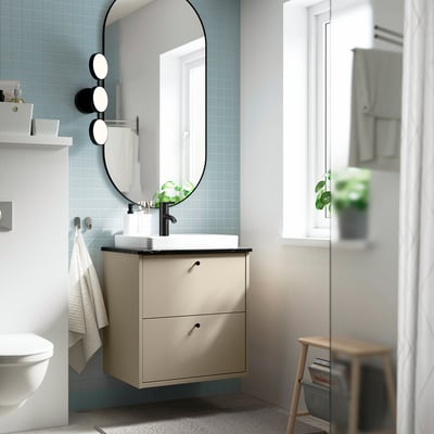 Beige kaptafel, half verzonken spoelbak, ronde spiegel, compact design.