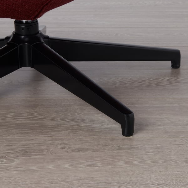 Close-up van de HAVBERG-stoel, met een stevige, roodbruine stoffen zitting en een stevig zwart onderstel met gladde wielen op een houten vloer.