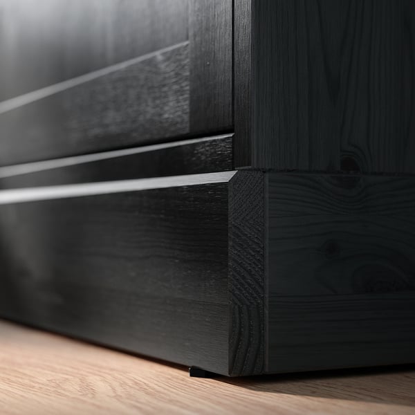 HAVSTA donkere houten kast close-up. Strak, rustiek ontwerp met geborstelde afwerking, glazen deuren en metalen handgrepen.