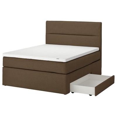 Bruine stoffen bed, met wit matras en open opberglade.