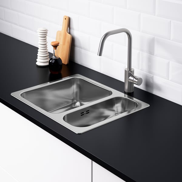 Moderne spoelbak met dubbele wastafel met kraan, zwart aanrechtblad, witte achterwand en waterafscheider.