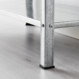 Metalen plankpoot met kunststof voet, stevig bevestigd met schroeven.