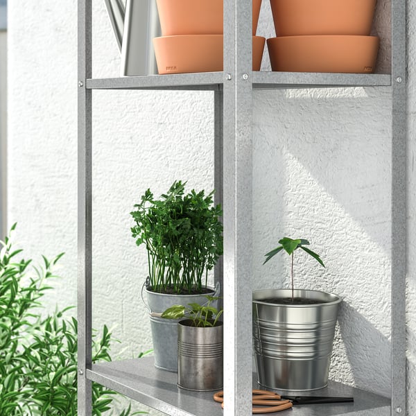 Metalen rekken bevatten plantenpotten, geschikt voor zowel binnen- als buitengebruik, ideaal voor het opbergen van spullen op balkons of in keukens.