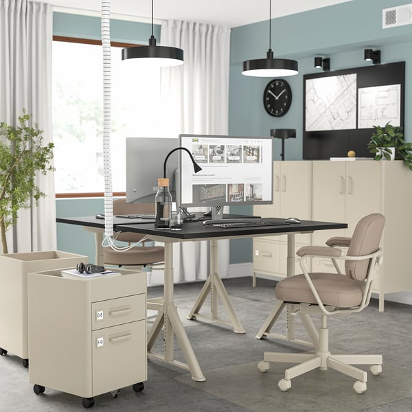 Thuiskantoor opstelling met IDÅSEN bureau, in hoogte verstelbaar, kabelnet, beige stoel, ramen, licht, decor.