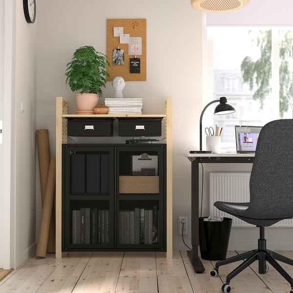 Thuiskantoor opstelling met IVAR zwarte opbergunit, houten vloer, plant, bureau, stoel en raam.