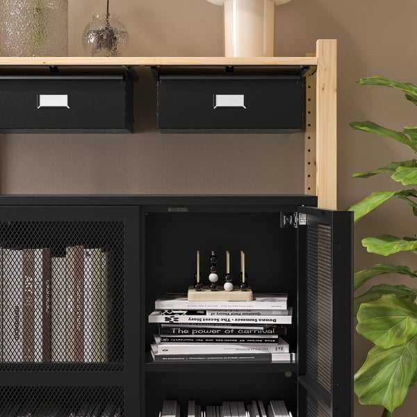 Zwart IVAR opbergmeubel met gaasdeuren en houten planken. Een deur open, met boeken en een decoratief item.