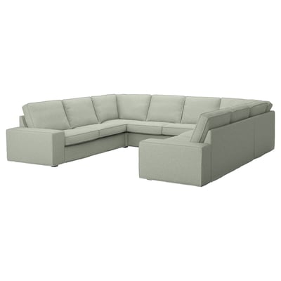 De KIVIK sectionele bank in lichtgrijs heeft een modern design, met lage armleuningen en een pluche, uitnodigende vorm voor comfort en ontspanning.