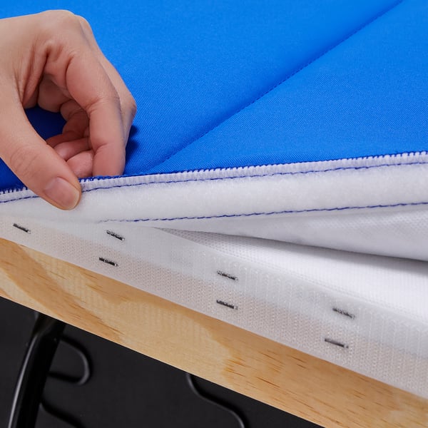 Afbeelding toont een hand die een schuimkussen in een blauwe stoffen hoes steekt, wat de kwaliteitsconstructie van het product aantoont.