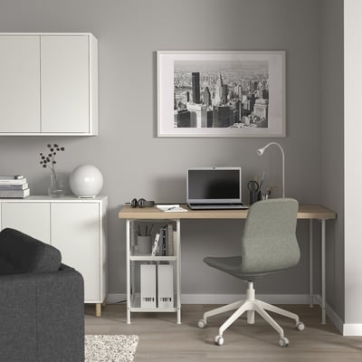 Moderne grijze thuiskantooropstelling met wit LAGKAPTEN-bureau, groene stoel en zwart-wit stadsgezicht kunstwerk, perfect voor werk of studie.