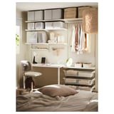 Klein kantoor aan huis in de slaapkamer. Bureau met stoel, planken, manden en lamp. Beige en witte inrichting.