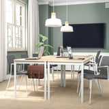 Moderne vergaderzaal met rechthoekige lijst, grijze stoelen, tv, hanglampen, groene muren, raam met gordijnen, installatie.