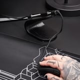 Zwarte muis bungee met strak ontwerp, waardoor snoeren uit de knoop blijven tijdens het gamen. Roestvrijstalen veer, stevige basis, moderne esthetiek.