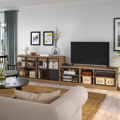Gezellige woonkamer met LANESUND tv-meubel en dressoir in houtafwerking, lichtbeige bank, grote flatscreen-tv, decoratieve vazen en ingelijste kunst aan de muur.