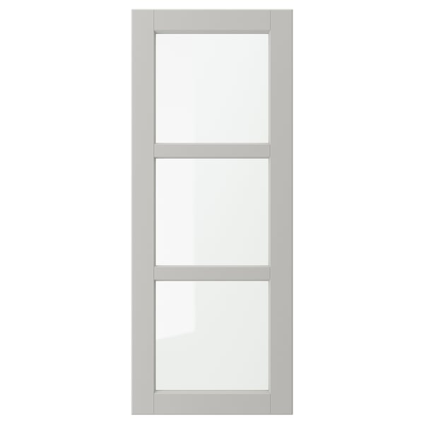 Een grijze LERHYTTAN kastdeur met een massief houten frame en afgeschuinde randen, met drie heldere glazen panelen in een rechthoekige lay-out.