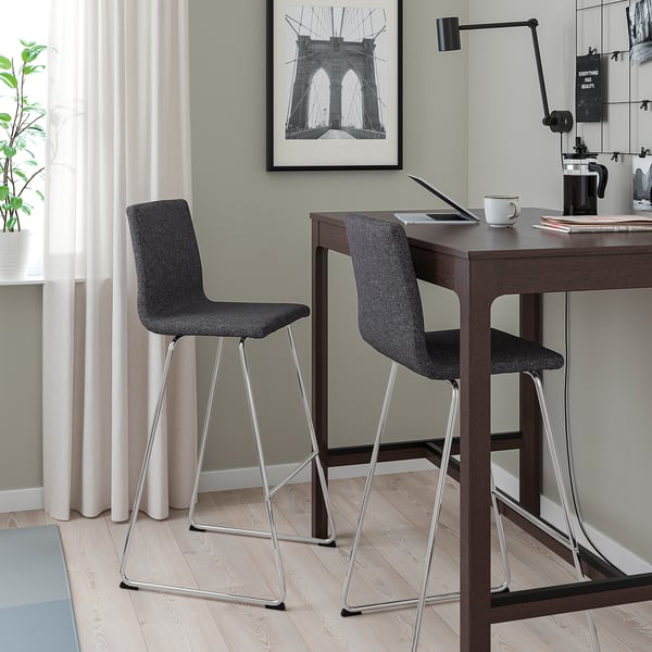 Grijze LILLÅNÄS barkrukken met gecapitonneerde zittingen aan hoge tafel met laptops, koffie en plant.