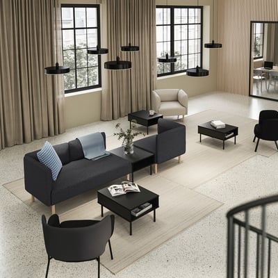 Moderne kantoorlounge met grijze LILLEHEM-banken, zwarte salontafels, zwarte stoelen en zwarte hanglampen.