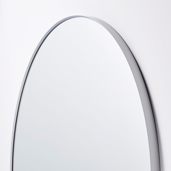 Boogvormige spiegel met dun metalen frame, strak en modern design. Reflecterend oppervlak, ideaal voor wanddecoratie.