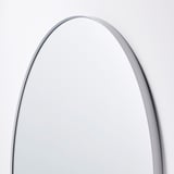 Boogvormige spiegel met dun metalen frame, strak en modern design. Reflecterend oppervlak, ideaal voor wanddecoratie.
