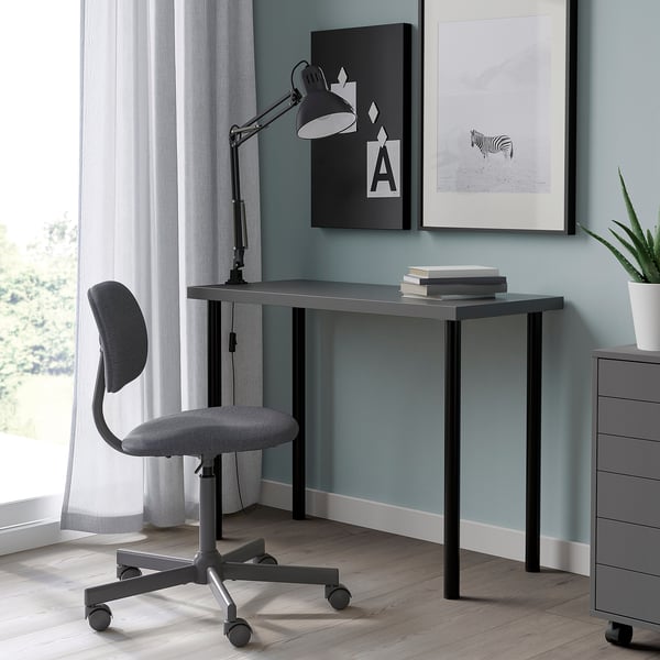 LINNMON bureau met grijs blad, zwarte lamp, kunst en plant.