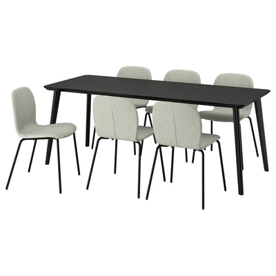 Moderne zwarte rechthoekige eettafel met vier lichtgrijze gestoffeerde stoelen. Eenvoudig, strak ontwerp voor zes zitplaatsen.