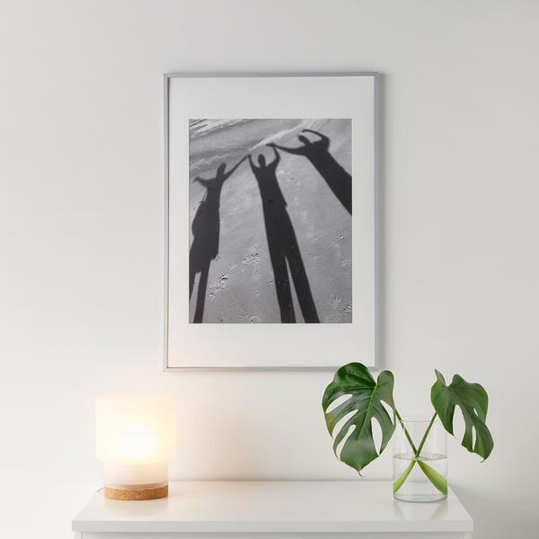 Zwart-wit kunstwerk van het vieren van handen, met kaars en plant voor warmte.