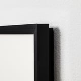 Zwarte fotolijst close-up, met strakke metalen rand en veilige hoekverbinding. Modern en minimalistisch design.