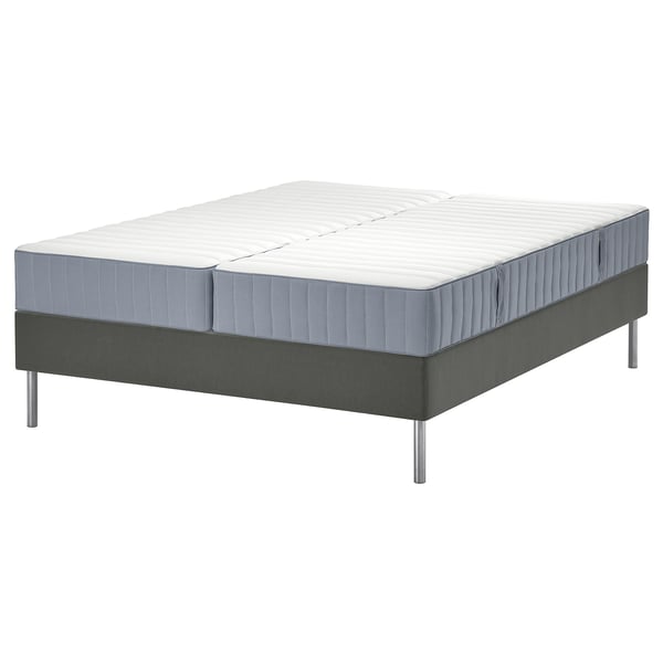 Het LYNGÖR bed in grijs. Het toont een grijze matras met witte bovenkant en grijze bodem op een grijs platformbed met metalen poten.