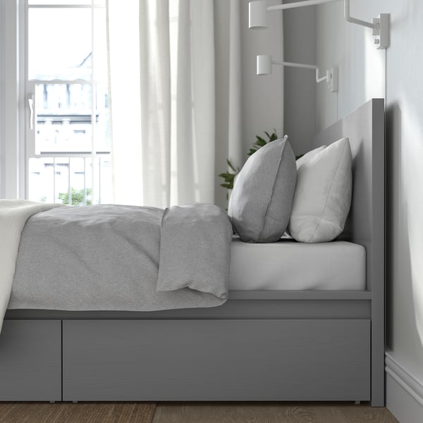 Een modern bedframe met lades eronder, met een hoog hoofdeinde en verstelbare bedzijden voor verschillende matrasdiktes.