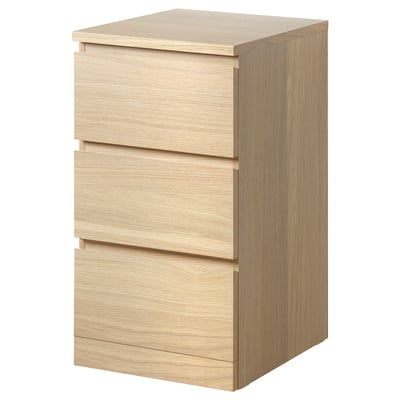 Een ikea MALM eikenhouten ladekast met 3 lades. Het heeft een strak, rechthoekig ontwerp met gladde, minimalistische fronten en is gemaakt van eikenfineer en spaanplaat.