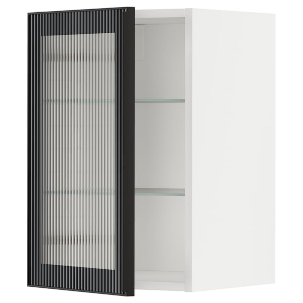 Een witte METOD keukenkast met een zwarte glazen deur met een rieten design. De kast heeft twee glazen legplanken.