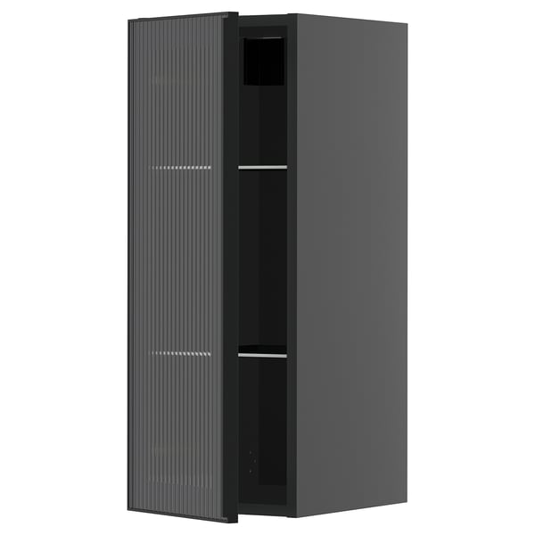 Een zwarte moderne keukenkast met een glazen deur met een metalen frame en verticaal rietontwerp, onderdeel van het METOD-systeem.