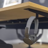 Koptelefoon hangt aan de MITTZON-bureauhaak.