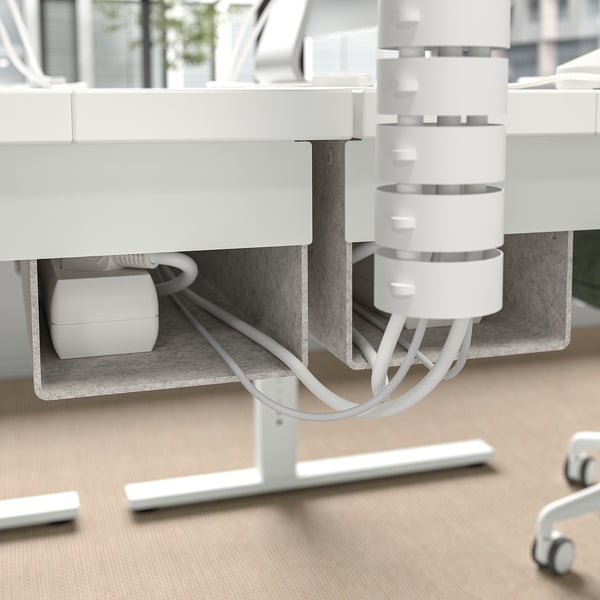 Toont de onderkant van een MITTZON-bureau, met de nadruk op de kabelbeheerlade en het hoogteverstellingsmechanisme.