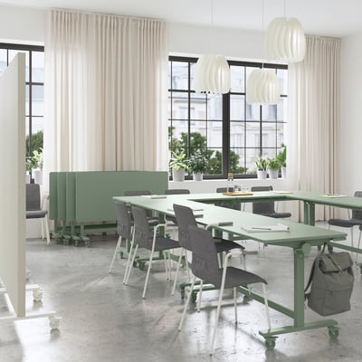 Modern kantoor met MITTZON groene opklapbare tafels, grijze stoelen, witte gordijnen, grote ramen en hanglampen.