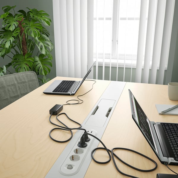 Kantoortafel met laptops en kabels, ideaal voor vergaderingen en werk, met kabelbeheer.