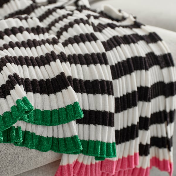 Zachte, gestreepte chenille plaid met groene, zwarte, witte en roze banden, netjes gevouwen.