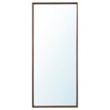 Een verticale NISSEDAL spiegel met een slanke bruine lijst. Het kan aan beide kanten hangen, is veilig voor badkamers en heeft een modern, eenvoudig ontwerp.