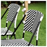 Zwart-wit geweven buitenstoelen. Monochrome strepen op rieten ontwerp met metalen frames. Perfect voor terras of tuin.