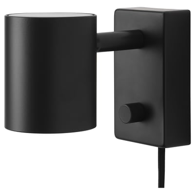 Een zwarte NYMÅNE wandlamp met een cilindrische kap en verstelbare arm, gemonteerd op een rechthoekige voet.