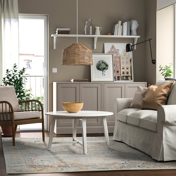 Oosters design vloerkleed in de woonkamer met salontafel, grijze stoel en kast. Duurzaam, vlekbestendig polypropyleen met latex achterkant.