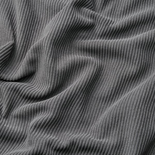 Close-up van dikke, getextureerde corduroy stof met zichtbare golvende lijnen, die de zachte en comfortabele kwaliteit laten zien.