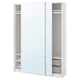 Een witte ikea PAX kledingkast met spiegelschuifdeuren, metalen planken en gaasmanden.