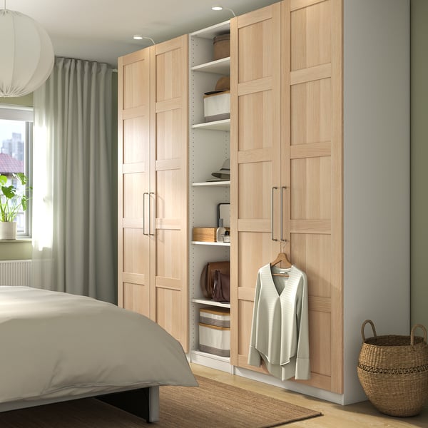 PAX kledingkast met open deur, manden, trui en minimalistisch design.