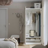 Open kledingkast met daarin kleerhangers, opbergdozen en accessoires.
