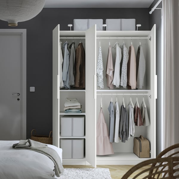 Open kledingkast met kleding, georganiseerde planken en opbergdozen, met interieurorganisatie.